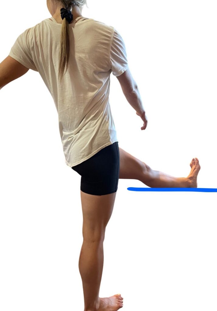 A woman is stretching on the floor with another person.